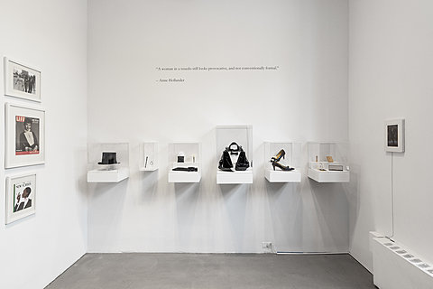 Multiple elements that make up formal wear attire in display cases lined up on the wall