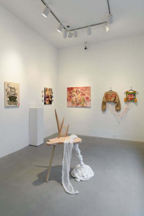 Installation image of the exhibition featuring a sculpture in the foreground with five art works on the wall behind it in the background.