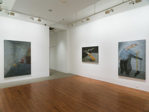 Installation image of three works on two walls in the exhibition. All the works are large, and dark grey, black and smokey colored, and blurry so the subject is rendered illegible. 