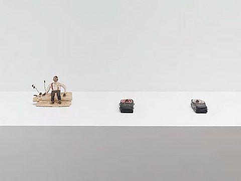 Three small ceramic figures on a white surface.
